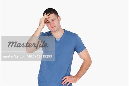 Young man having a headache against a white background