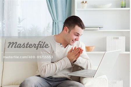 Happy man using a notebook in his living room