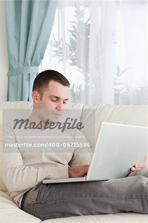 Portrait of a man relaxing with a laptop in his living room