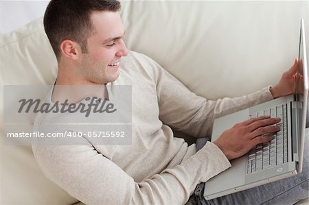 Happy man relaxing with a notebook in his living room