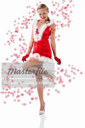 young and sexy woman in red santa claus dress with hood and white fur and gloves standing on one foot