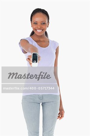 Close up of smiling woman presenting her phone on white background