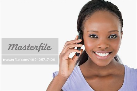 Close up of young smiling woman on the phone on white background