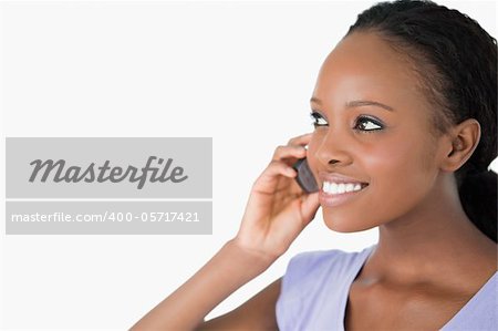 Close up of smiling woman talking on her phone on white background