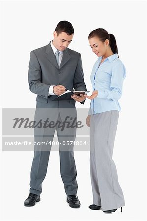 Business partner looking at clipboard together against a white background