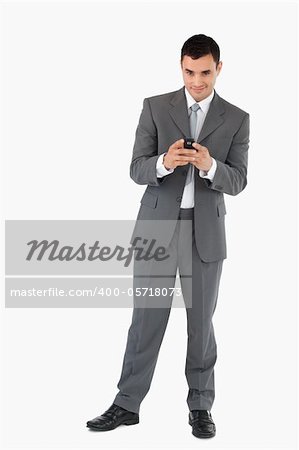 Smiling businessman holding his cellphone against a white background