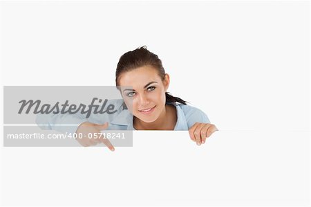 Businesswoman pointing on sign under her against a white background