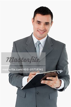 Smiling businessman taking notes against a white background