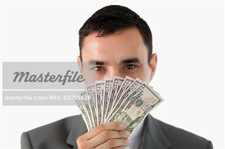 Businessman smelling on banknotes against a white background