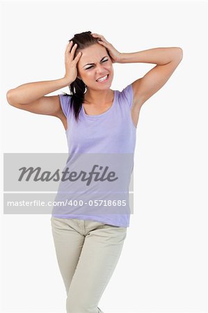 Young female having migraine against a white background
