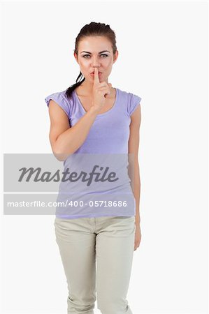 Young female asking for silence against a white background