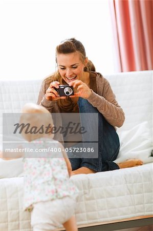 Modern mother making photos of baby at home