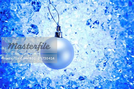 christmas silver bauble on blue winter ice background