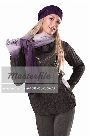 fashion shot of a beautiful blonde wearing a knitted cap, a scarf and gloves to grey sweater and pants