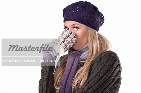 beautiful and natural blonde girl holding a hot cup of tea wearing a purple knitted cap and scarf and gloves