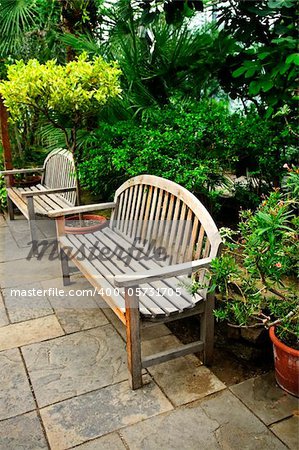 Lush green garden with stone landscaping and benches