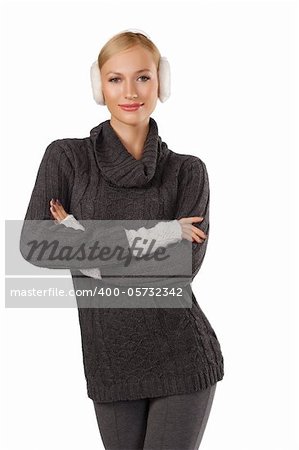 young pretty woman wearing white earmuffs and gray wool sweater be ready to go out in a cold winter day standing and looking at the camera against white background