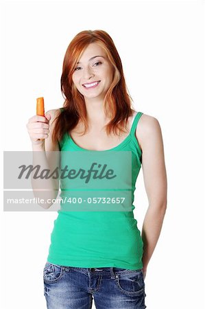 Pretty caucasian standing teen girl holding a carrot ang smiling. Isolated on white.