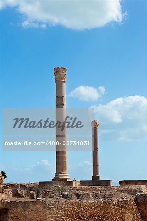 Two ancient roman pillars against a blue sky
