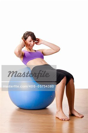 Beautiful young and athletic woman making exercises on a fitness ball