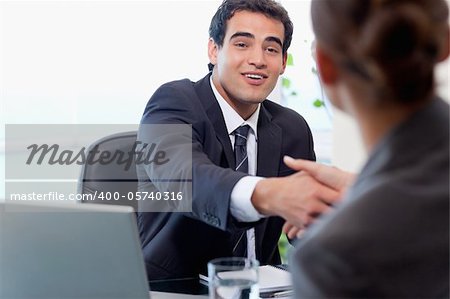Smiling manager interviewing a female applicant in his office