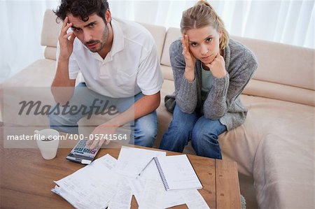 Worried couple doing their accounting in their living room