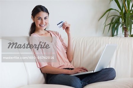 Joyful woman shopping online in her living room