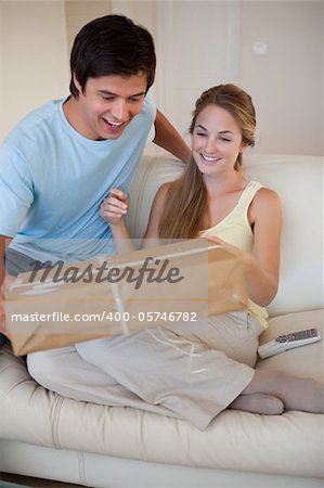 Portrait of a couple looking at a package in their living room