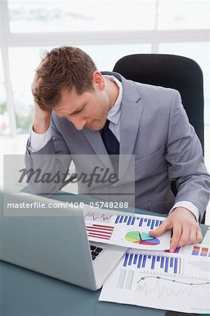 Businessman at his desk frustrated by market research results