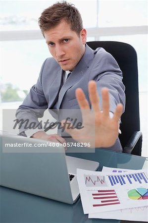 Businessman at his desk signals stop