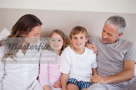 Smiling family lying on a bed in the morning