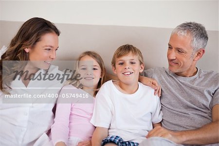 Good looking family lying on a bed in the morning