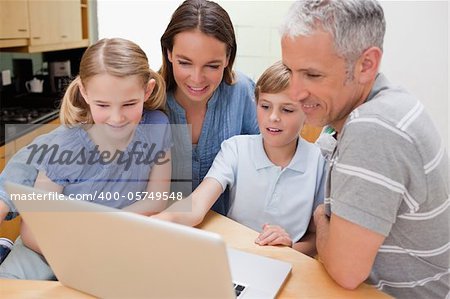 Lovely family using a notebook in their kitchen