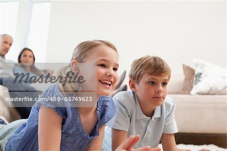 Children playing video games while their parents are watching in a living room