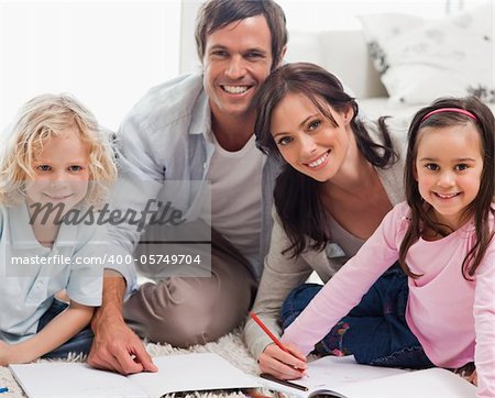 Smiling family drawing together in a living room