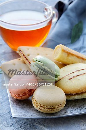 traditional french macarons with tea set on the background