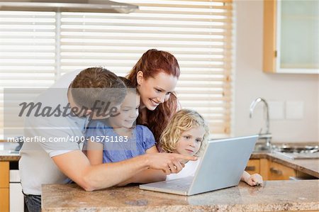 Family together with laptop in the kitchen