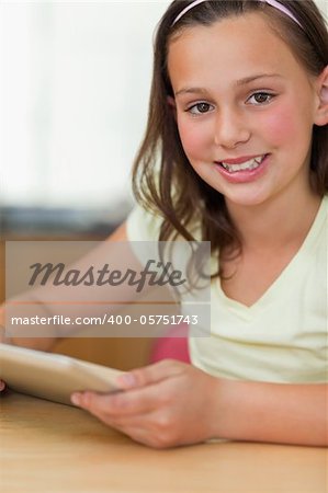 Girl sitting at the table with tablet