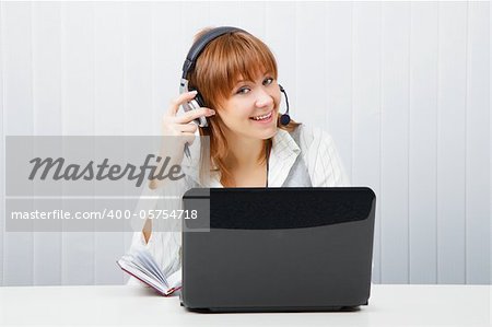 girl in headphones with a microphone and a laptop