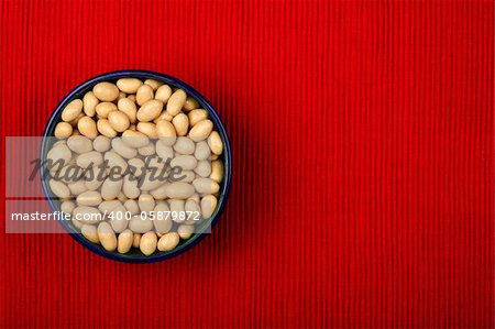 Bowl of dragee on red cloth background
