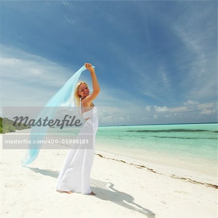 woman with a white fabric in his hands on the beach