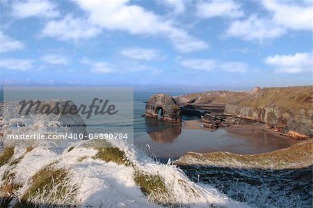 snow covered view of beach cliffs and the virgin rock in ballybunion county kerry ireland