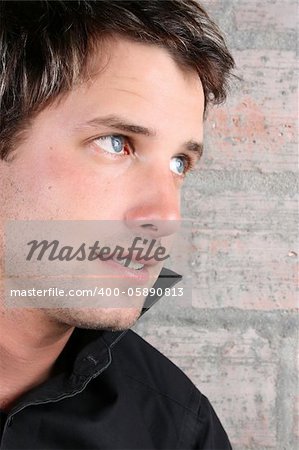 Male model against a rough brick wall background