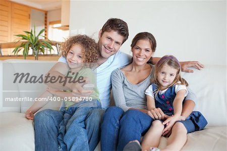 Happy family watching TV together in their living room