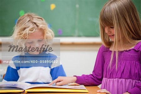 Pupils reading a book in a classroom