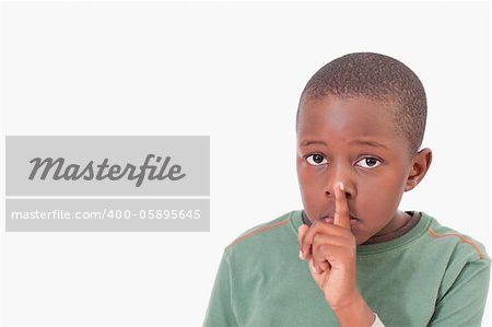 Boy asking for silence against a white background