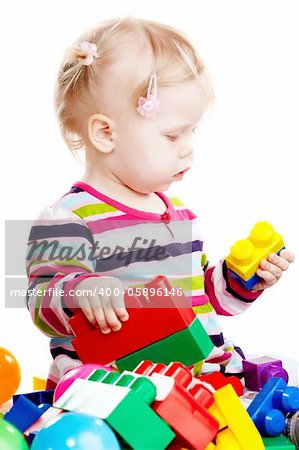 Little baby girl playing with balls isolated on white