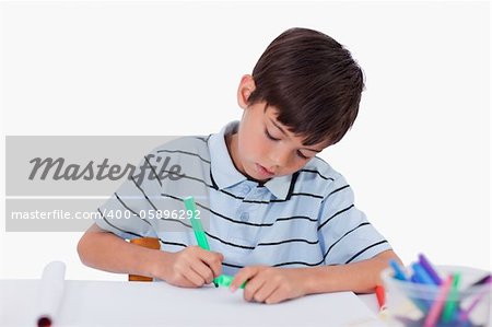 Young boy drawing against a white background