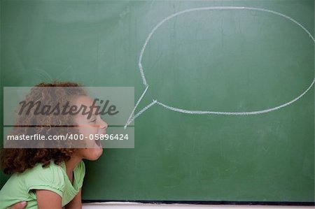 Schoolgirl posing with a speech bubble in a classroom