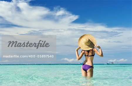 Girl on a tropical beach with hat